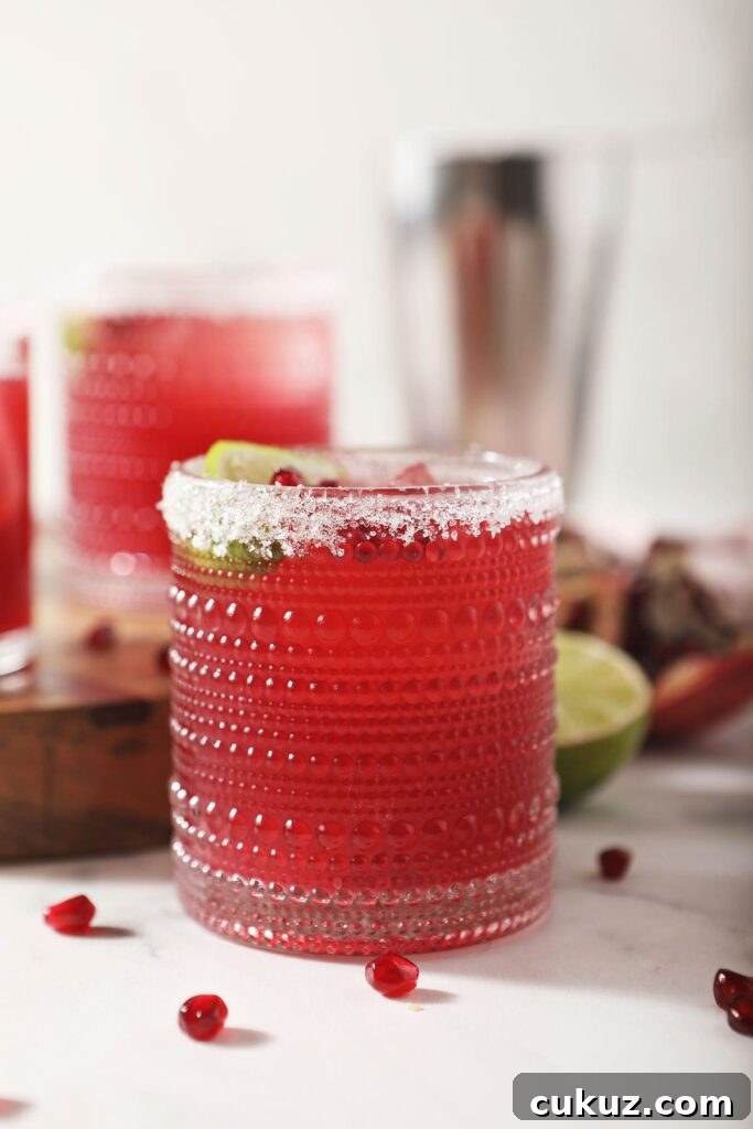  Three pomegranate margaritas with sugar rims on marble