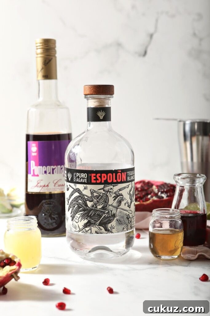 Tequila, pomegranate liqueur and other margarita ingredients on marble