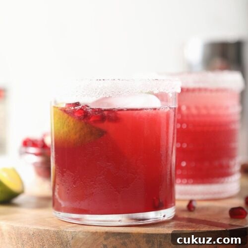 Two pink margaritas on a wooden board