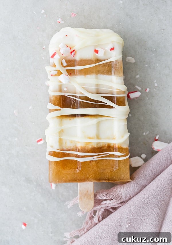 Peppermint Cold Brew Popsicles Recipe: Refreshing Iced Coffee Treat 5 White chocolate and cold brew popsicle striped with white chocolate drizzled over it.