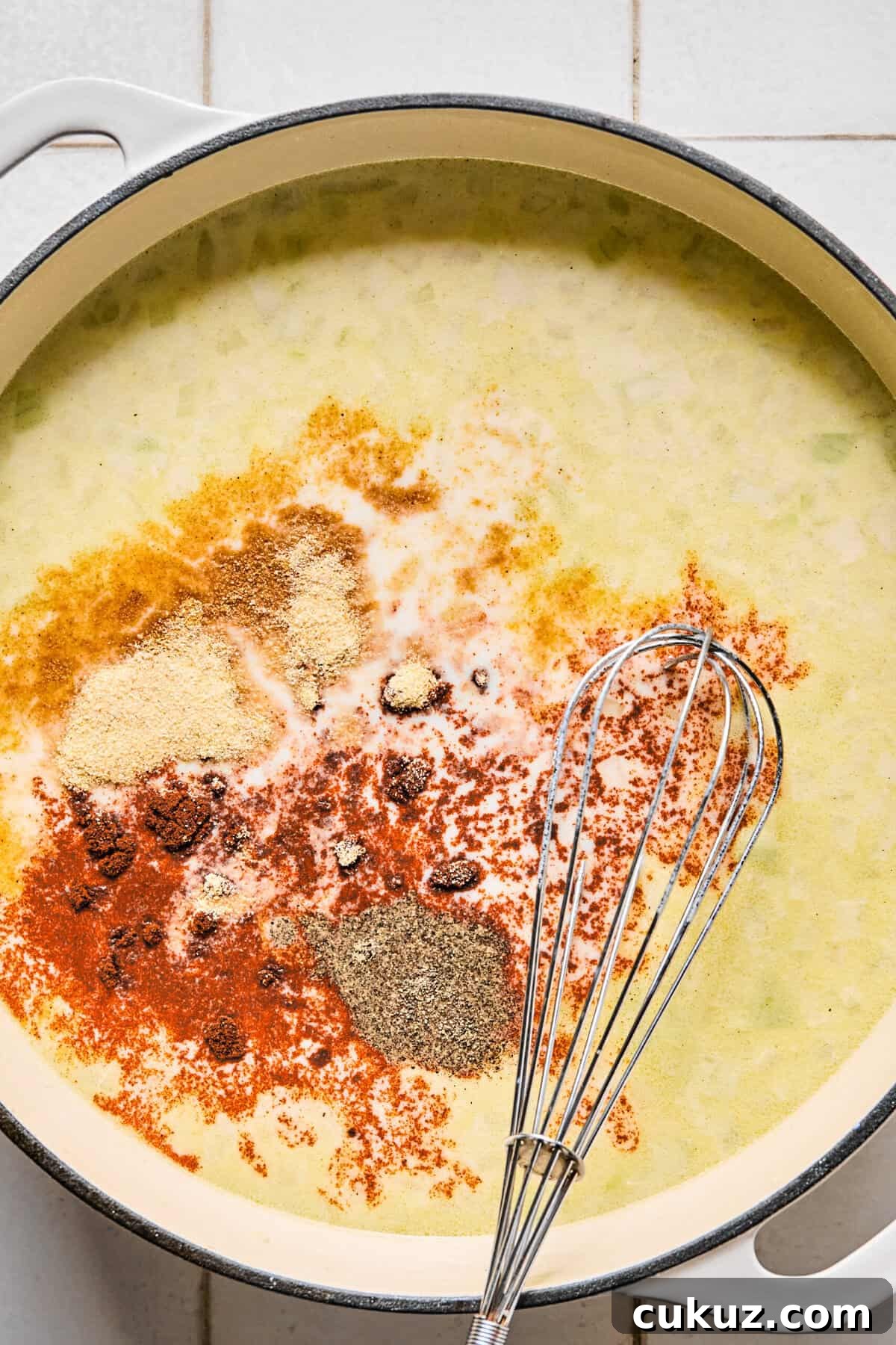 Seasonings in the pan of milk, broth, flour, and sautéed onions and garlic.