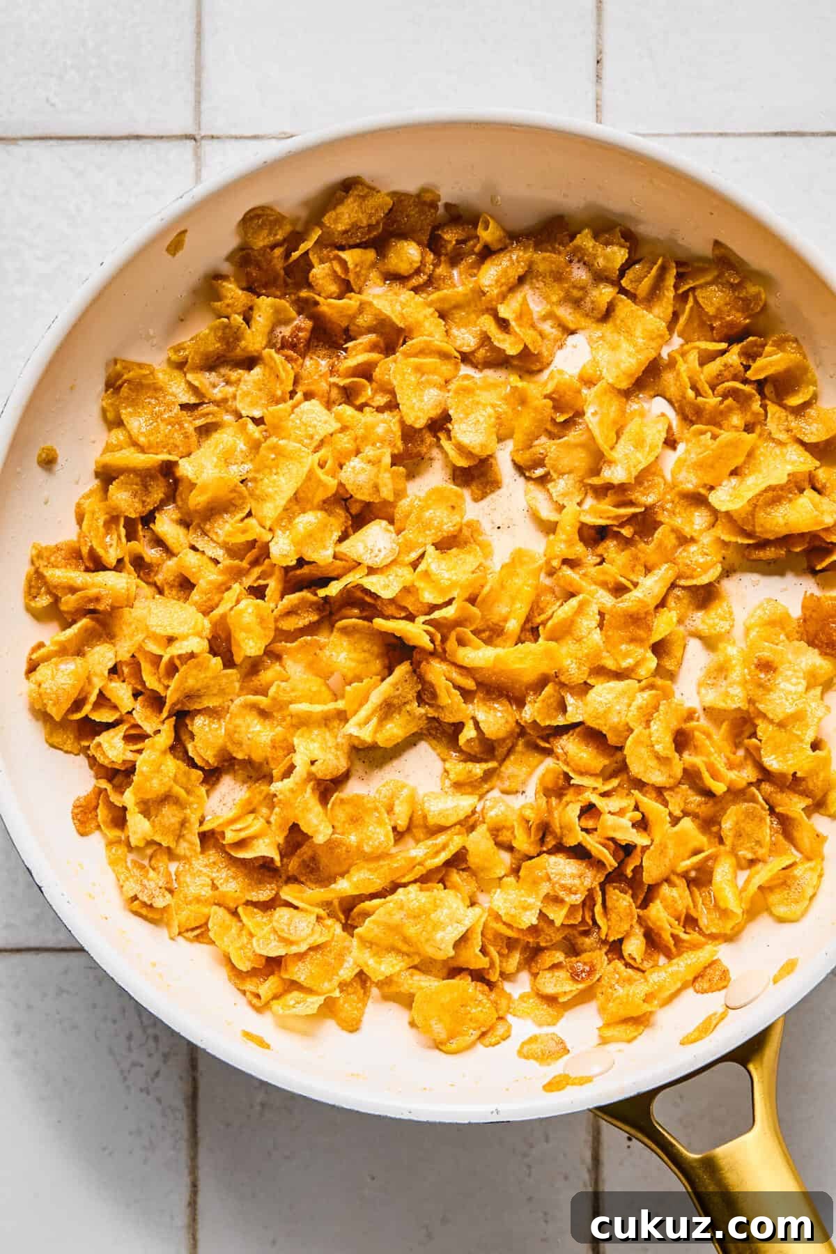 Gluten-free cornflakes being toasted in a large pan.