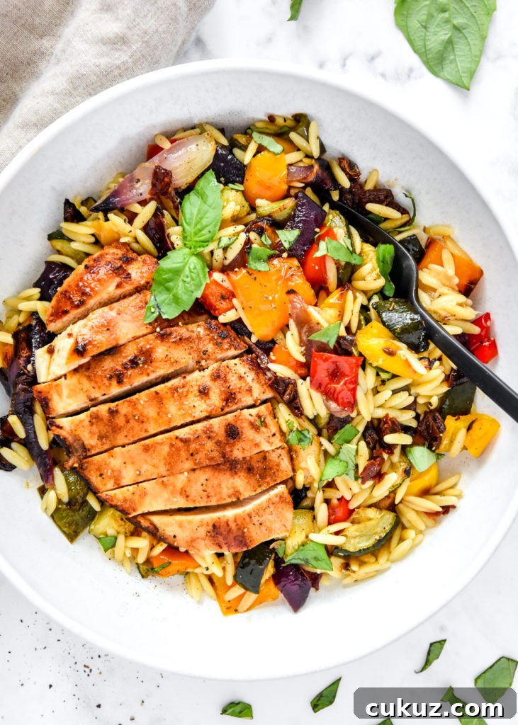 Juicy Thin-Sliced Stovetop Chicken Breasts in 20 Minutes 12 roasted vegetable orzo salad with sliced chicken breast in a white bowl.
