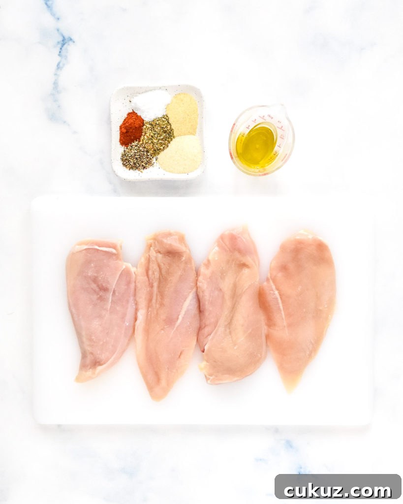 Juicy Thin-Sliced Stovetop Chicken Breasts in 20 Minutes 5 raw chicken breasts on a cutting board with seasonings and oil on the side.