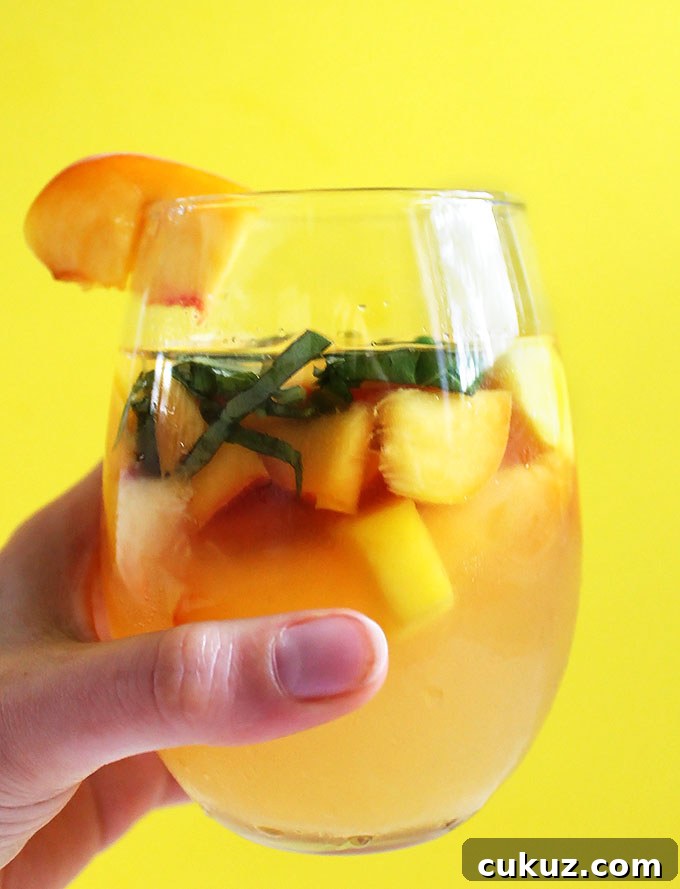 Peach Mango Sangria. Bursting with peaches and mangos! So easy to make! Summertime in a pitcher. #sangria #summercocktail #refinedsugerfree #recipe | robustrecipes.com