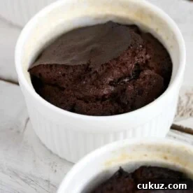 A chocolate soufflé in a white ramekin