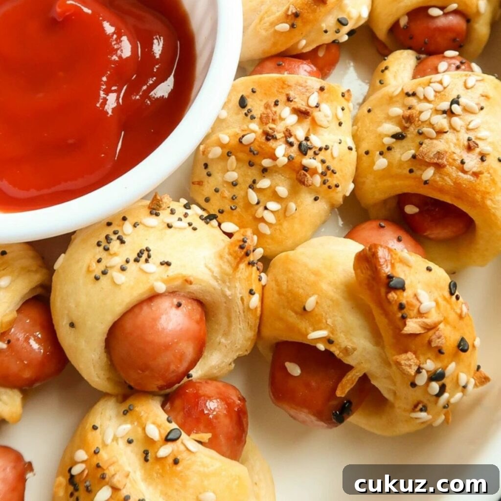 Pigs in a blanket made with mini hot dogs wrapped in flaky crescent rolls, sprinkled with everything bagel seasoning.