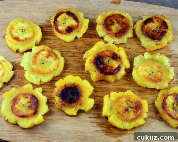 Smashed plantain slices on a wood board