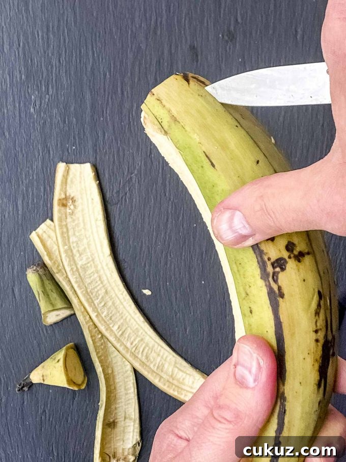 Scoring the skin of a plantain in order to peel it