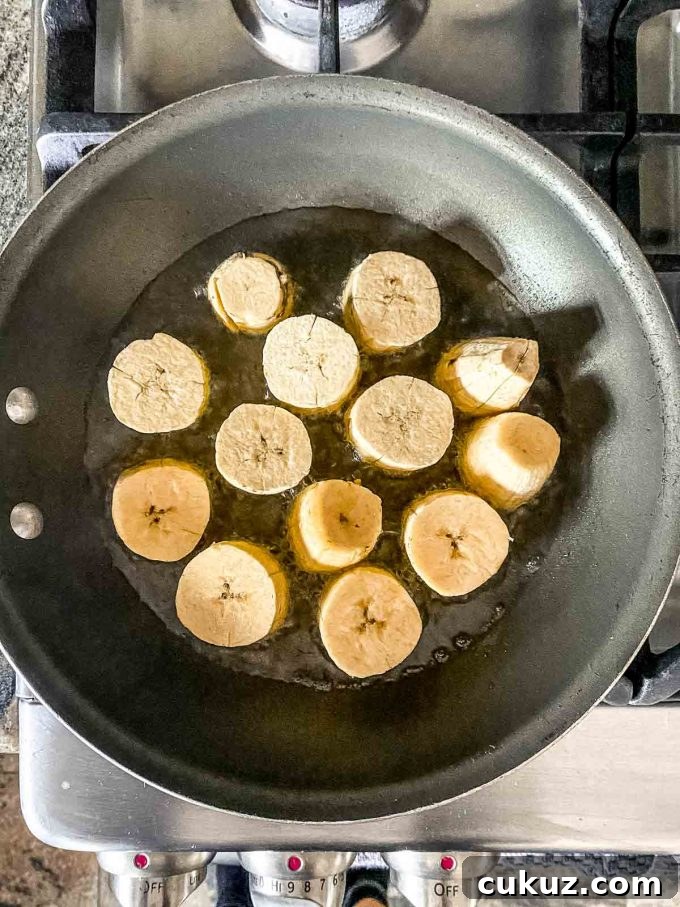 Cooking platntain slices on a skille