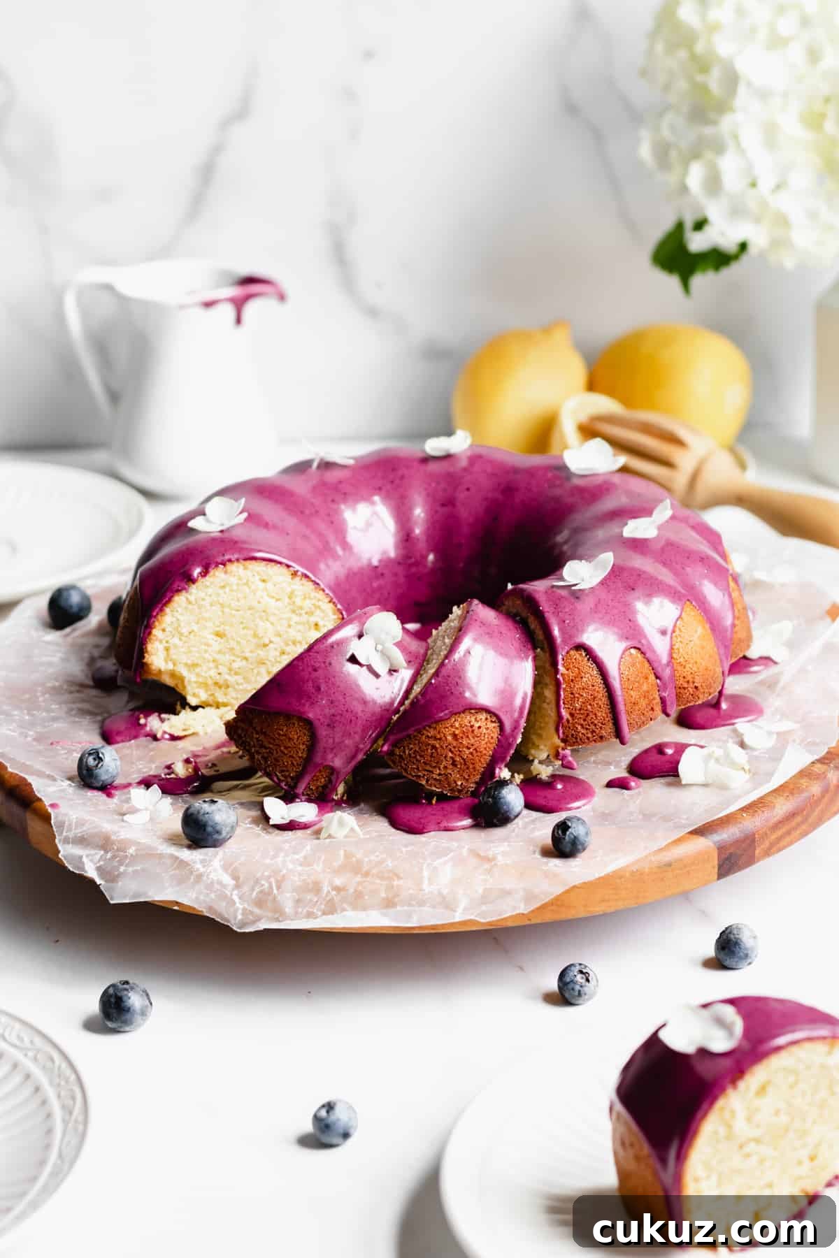 Lemon pound cake on a platter with a few slices leaning over.