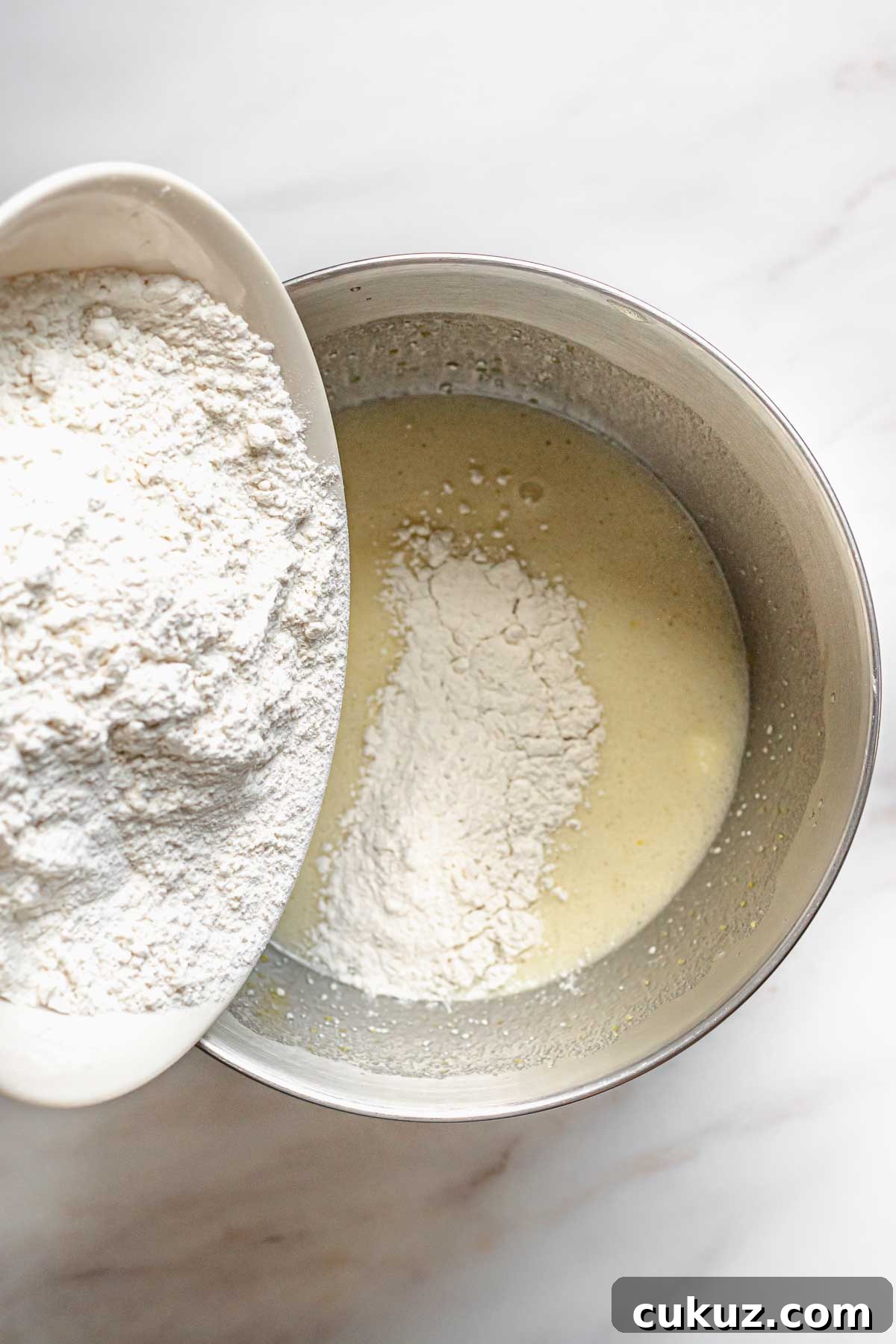 Dry ingredients being poured into the batter.