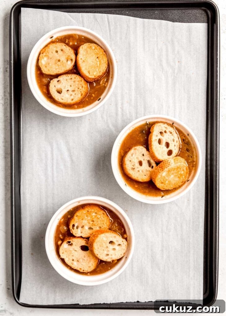 french onion chicken soup topped with toasted baguette slices