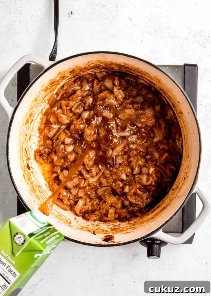 broth being added to caramelized onions