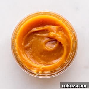 A jar of homemade milk jam viewed from the top to show the gooey, thick texture.