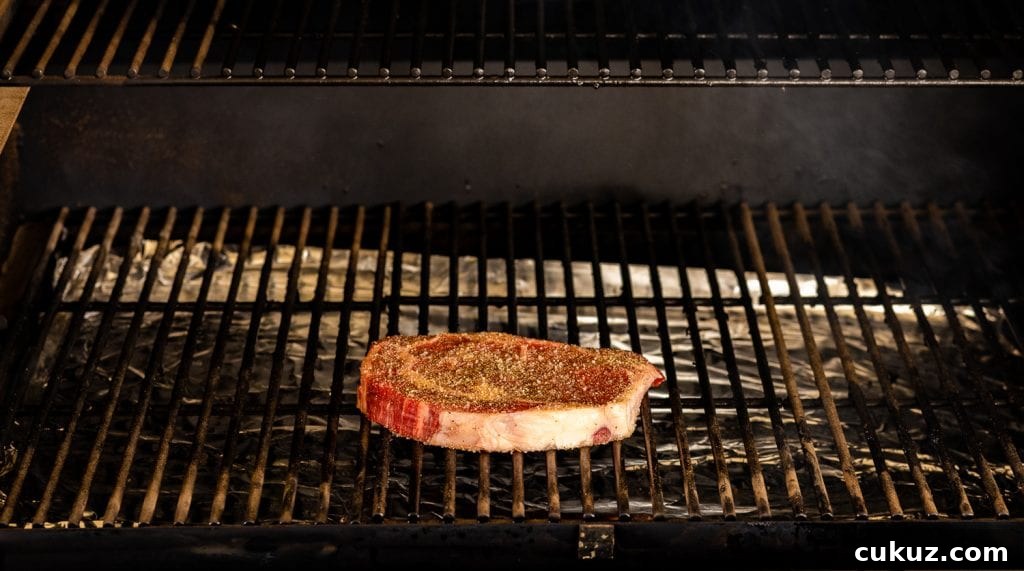 Seasoned ribeye steak on a pellet grill.