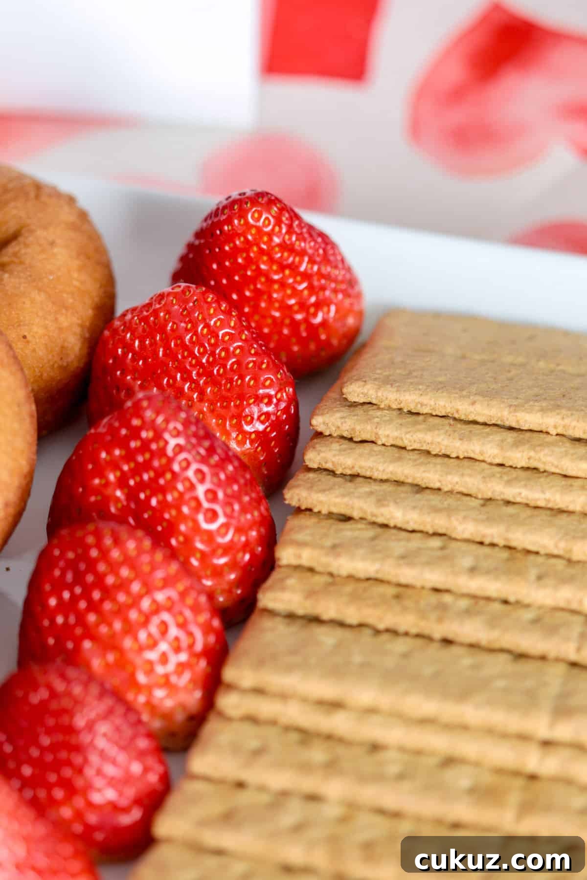 Strawberries and graham crackers on plate.