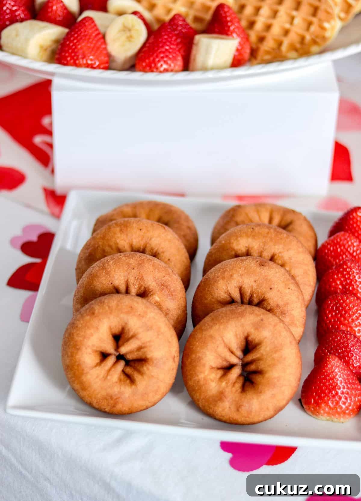Donuts and strawberries on plate.