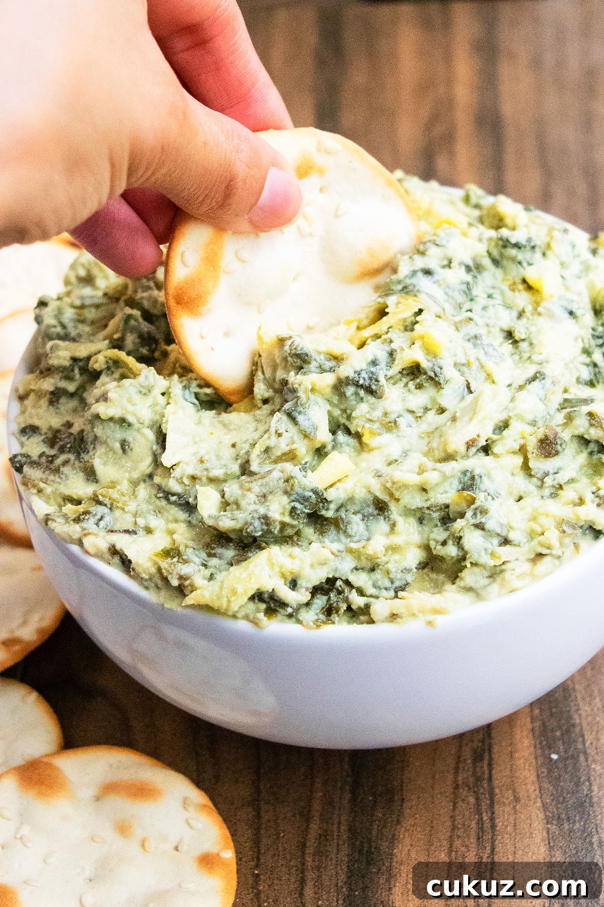 Creamy One‑Bowl Spinach and Artichoke Dip Recipe 4 Cracker being dunked in hot dip.