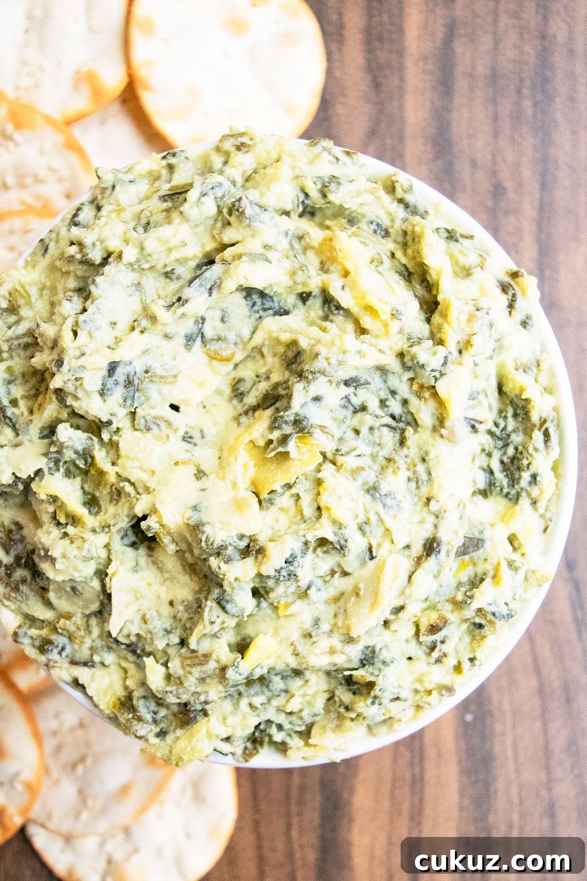 Creamy One‑Bowl Spinach and Artichoke Dip Recipe 5 Overhead shot of creamy dipping sauce in white bowl on wood background.