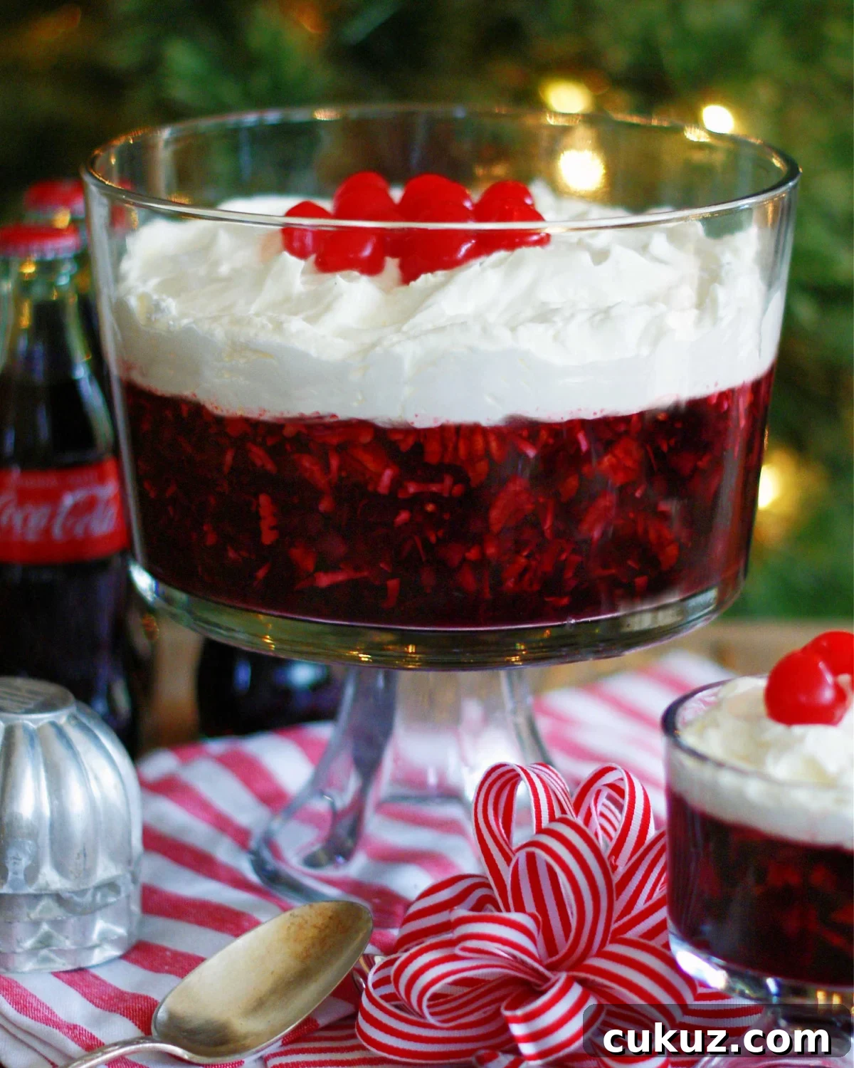 Coca cola jello salad in a trifle dish. Made with cherries, pineapple, coconut pecans, coca-cola and cherry gelatin.
