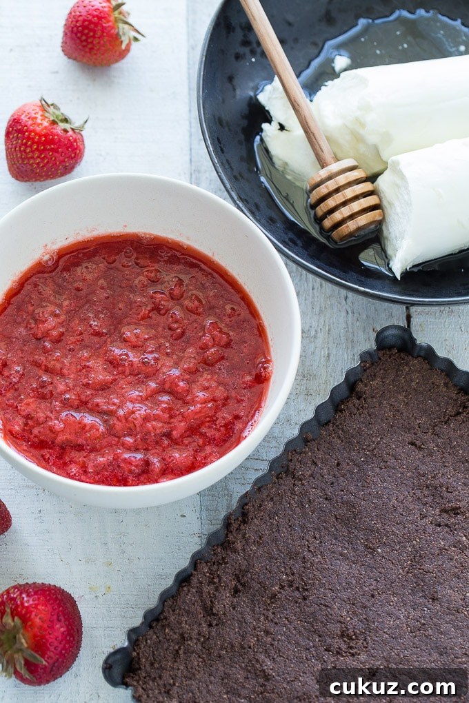 All the ingredients for Frozen Strawberry Goat Cheese Bars layed out on a white surface.