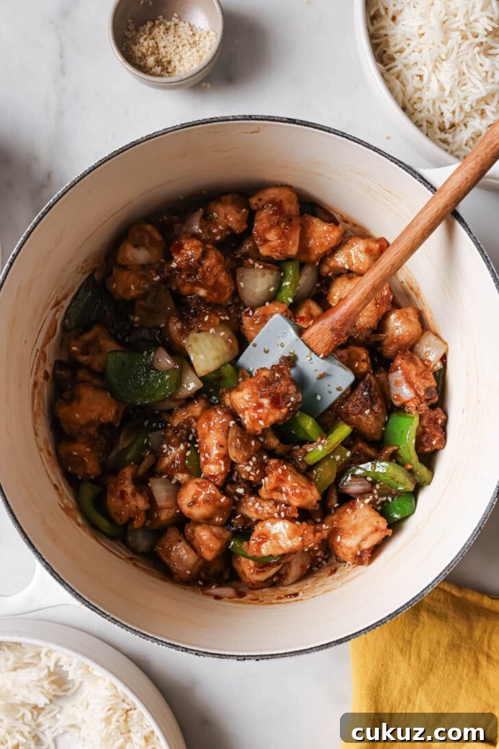 Top view of Honey Ginger Chicken in a pot surrounded by bowls of rice.