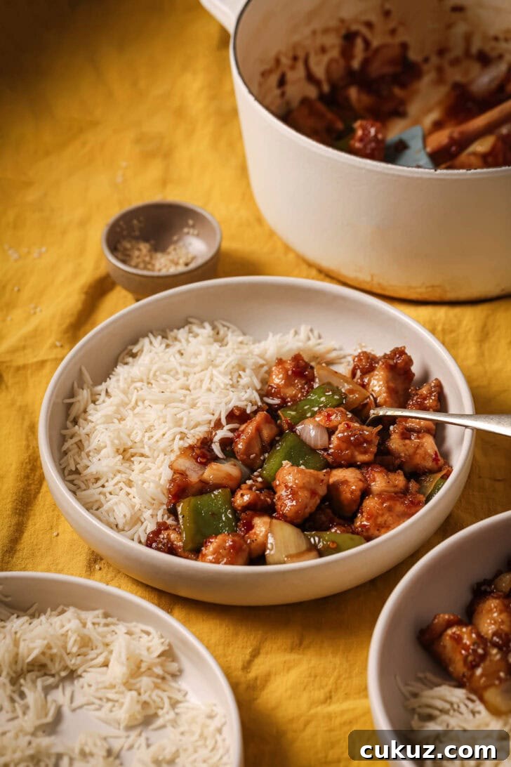A plate of Honey Ginger Chicken on the table along with the serving pot in the background.