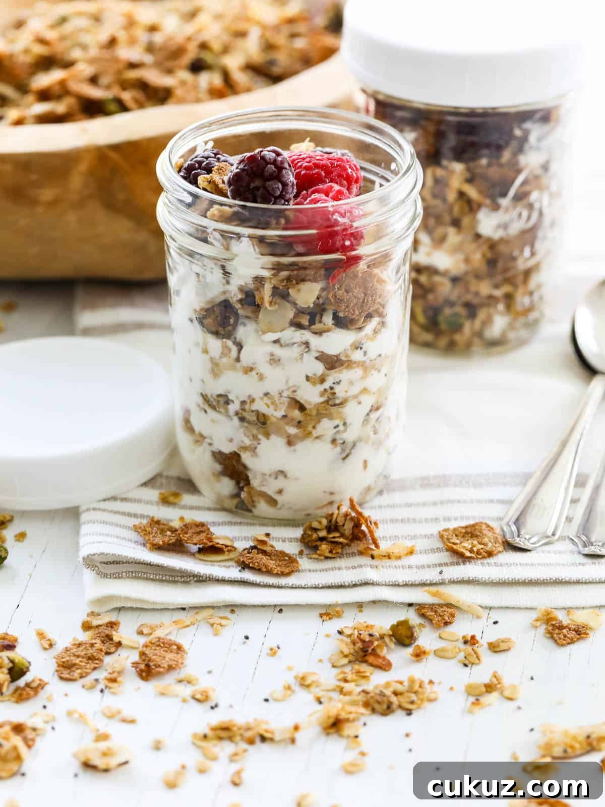 A layered yogurt parfait with granola and fresh raspberries and blackberries.