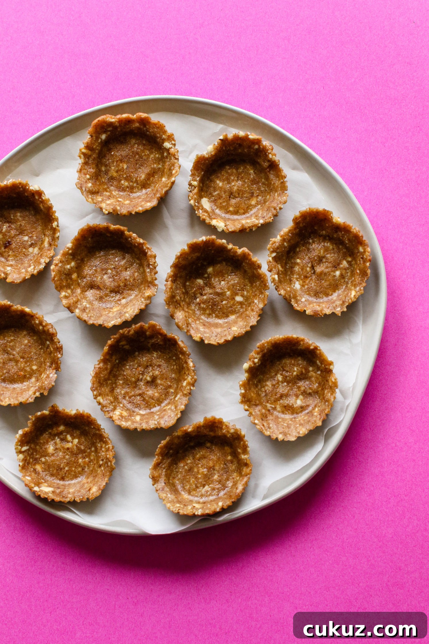 date-nut crust formed into tarts on parchment lined plate by Flora & Vino