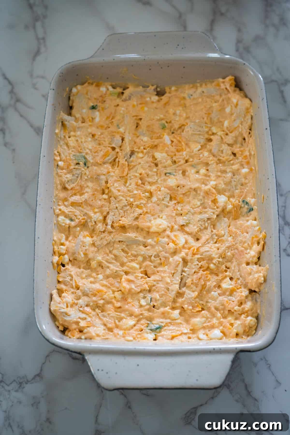 Buffalo chicken dip, made with cottage cheese, served in a white baking dish.
