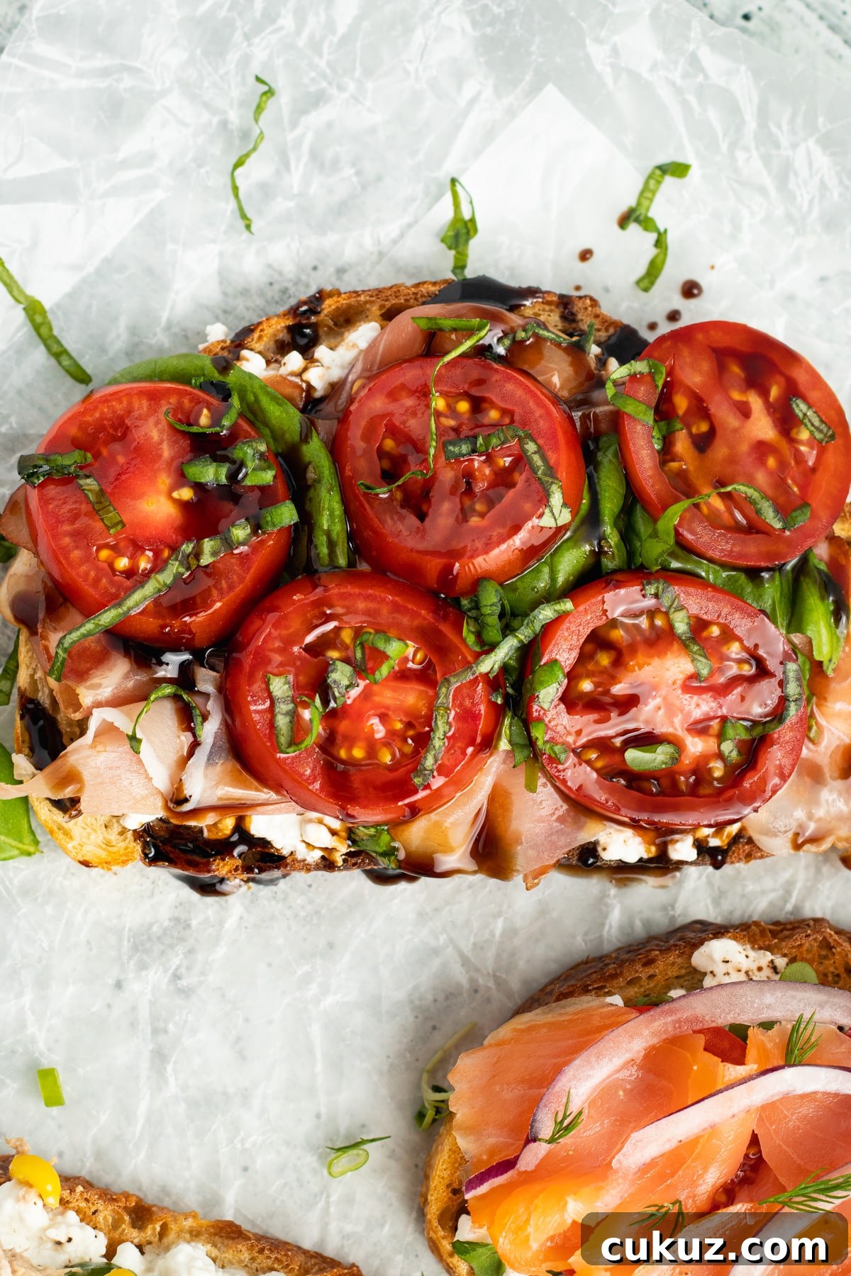 Picture of tomato, basil and prosciutto toast.
