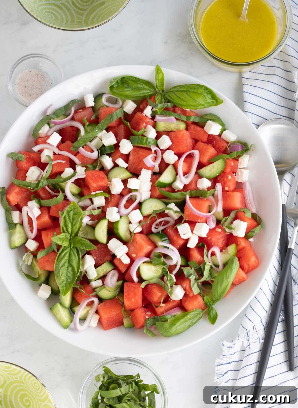 Colorful watermelon salad with feta, shallots, basil, and cucumber.
