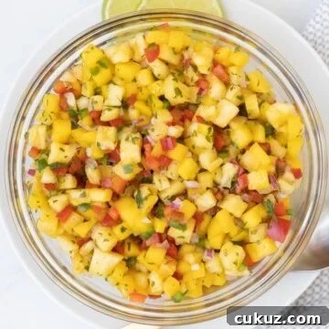Bowl of bright tropical colored pineapple mango salsa.