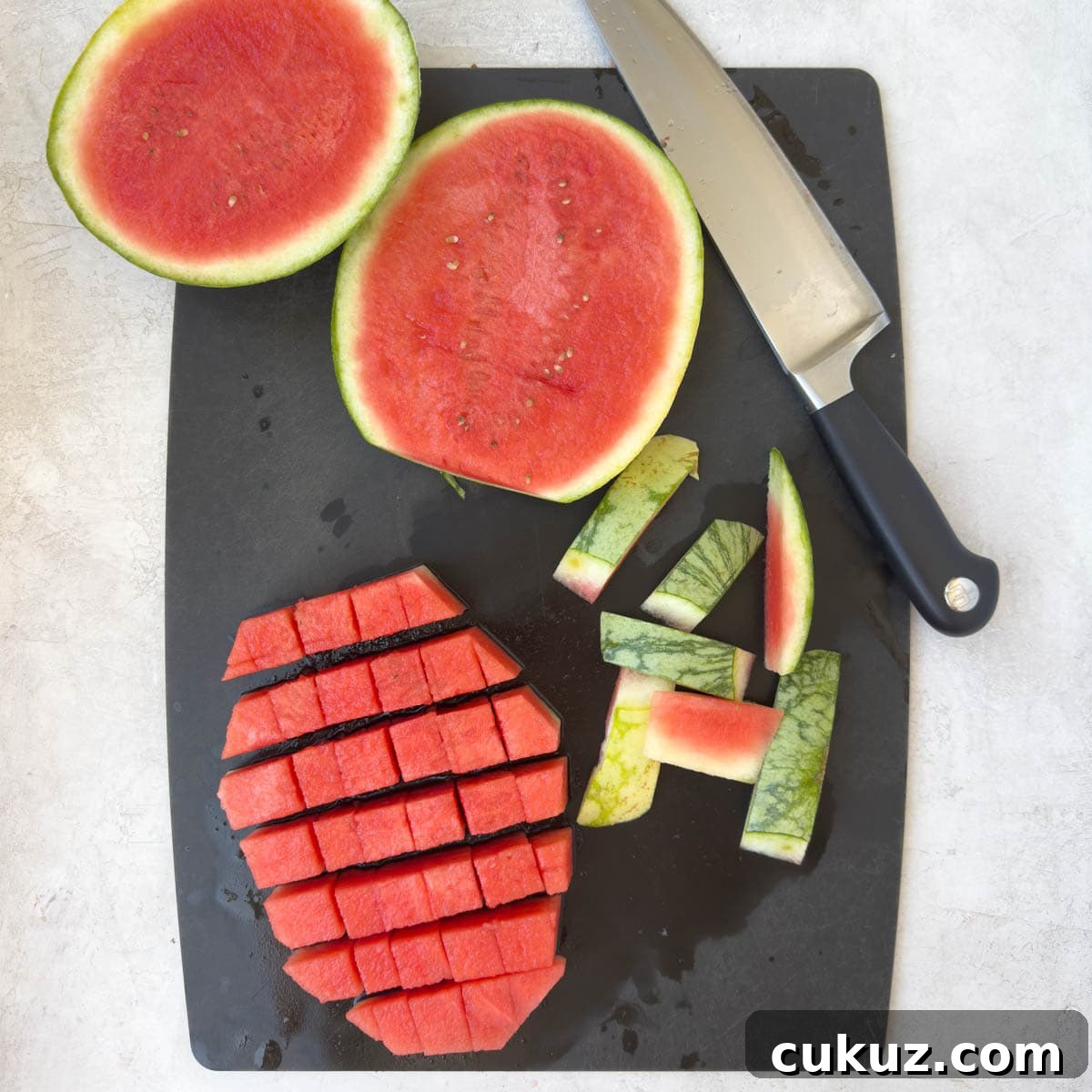 Cutting watermelon slices into cubes.