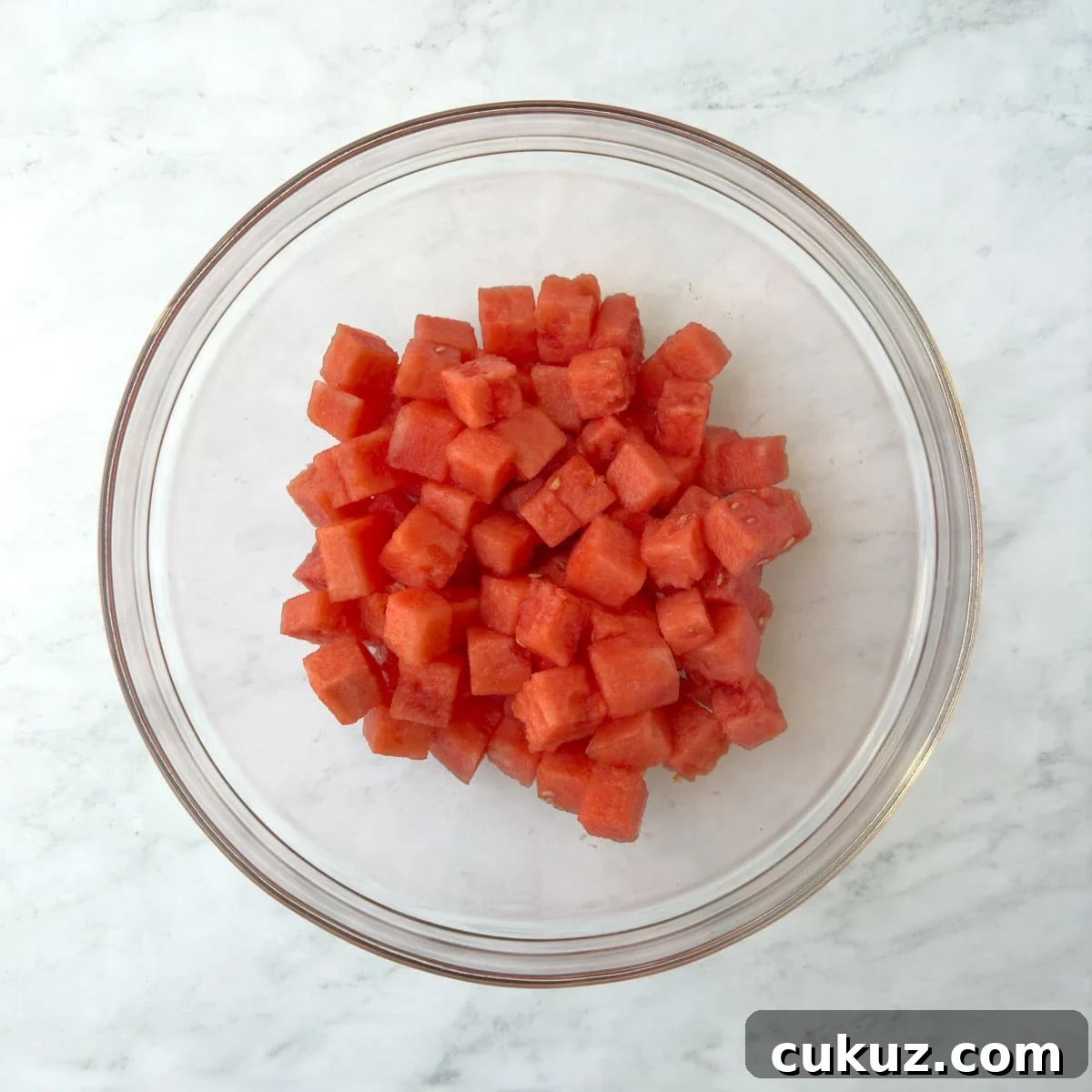 Red watermelon cubes in a glass bowl.