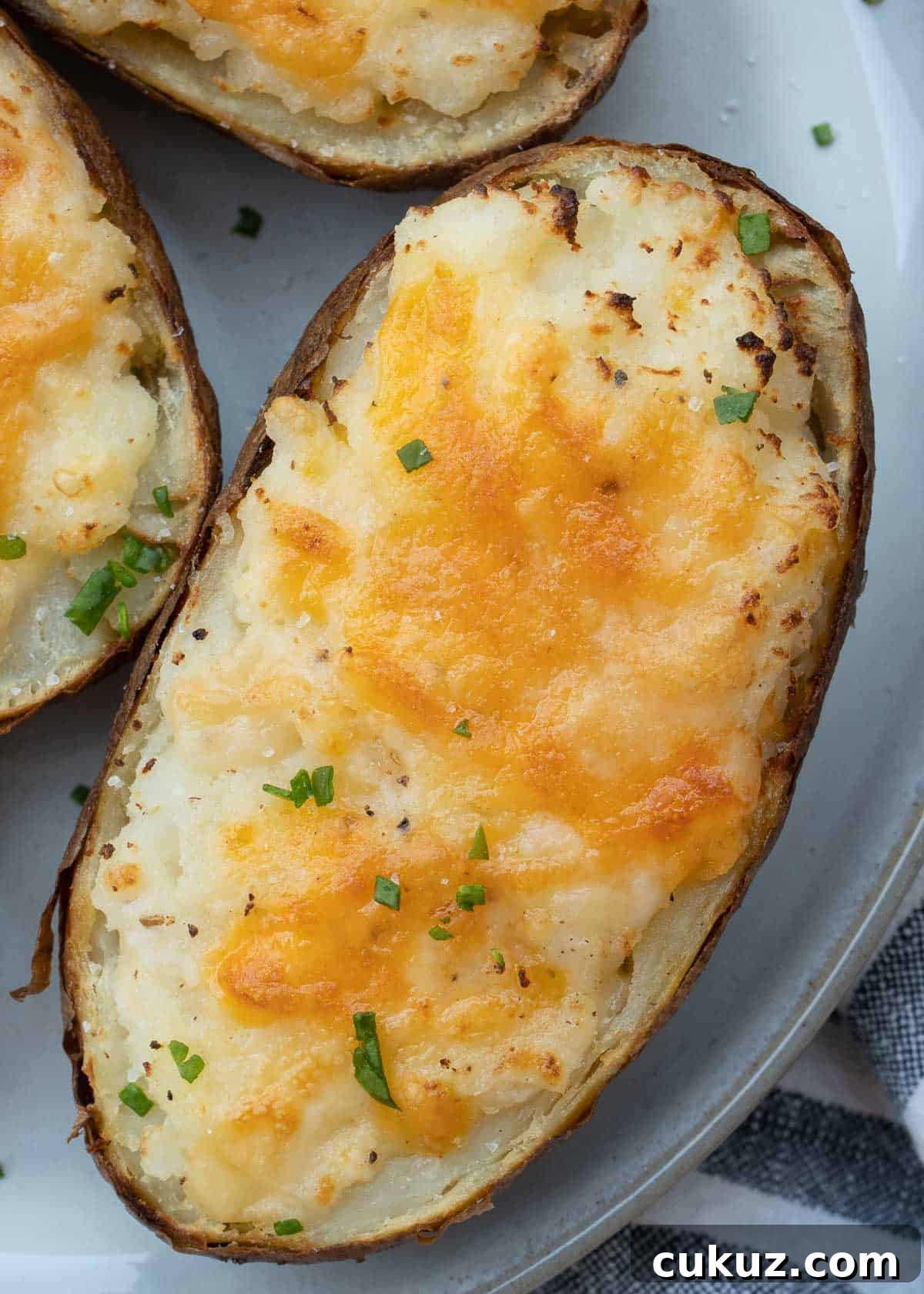 These Air Fryer Twice Baked Potatoes are the perfect side dish or appetizer! Get that cheesy center and ultra-crispy potato skin quickly with this easy recipe.