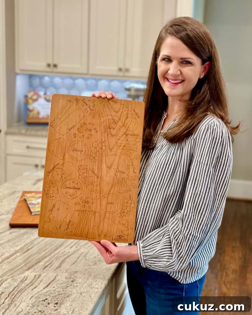 Maegan Brown holding her signature board while standing in her kitchen.