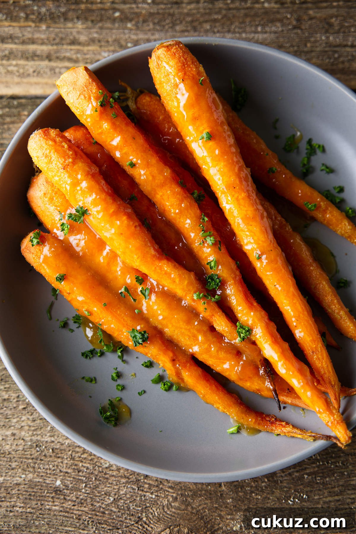 Carrots in a bowl with glaze drizzled over the top.