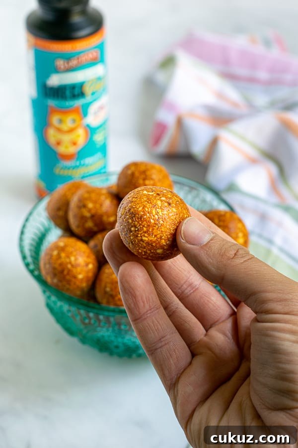 hand holding an orange tropical energy bite
