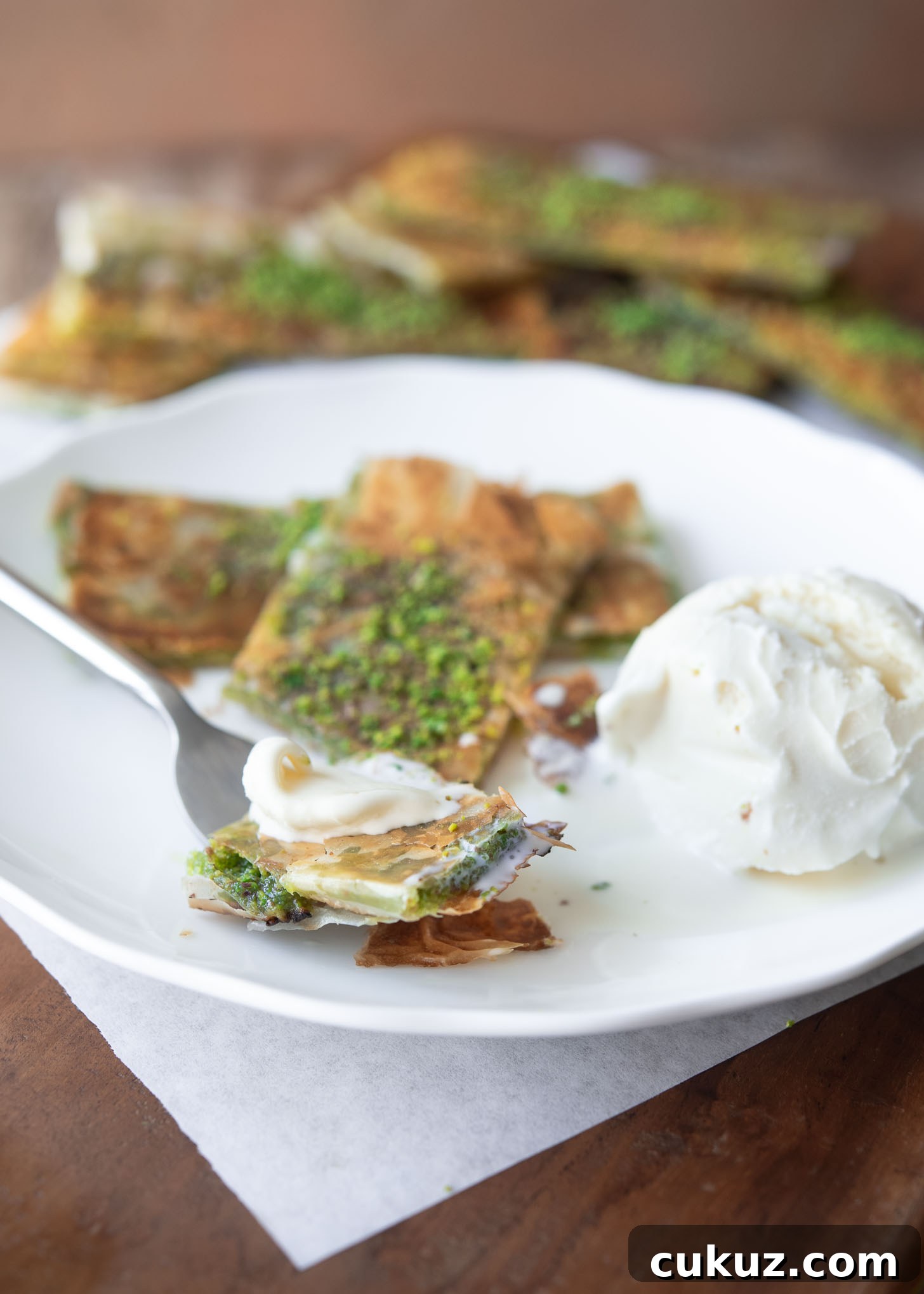 Pistachio Katmer dessert served with vanilla ice cream.