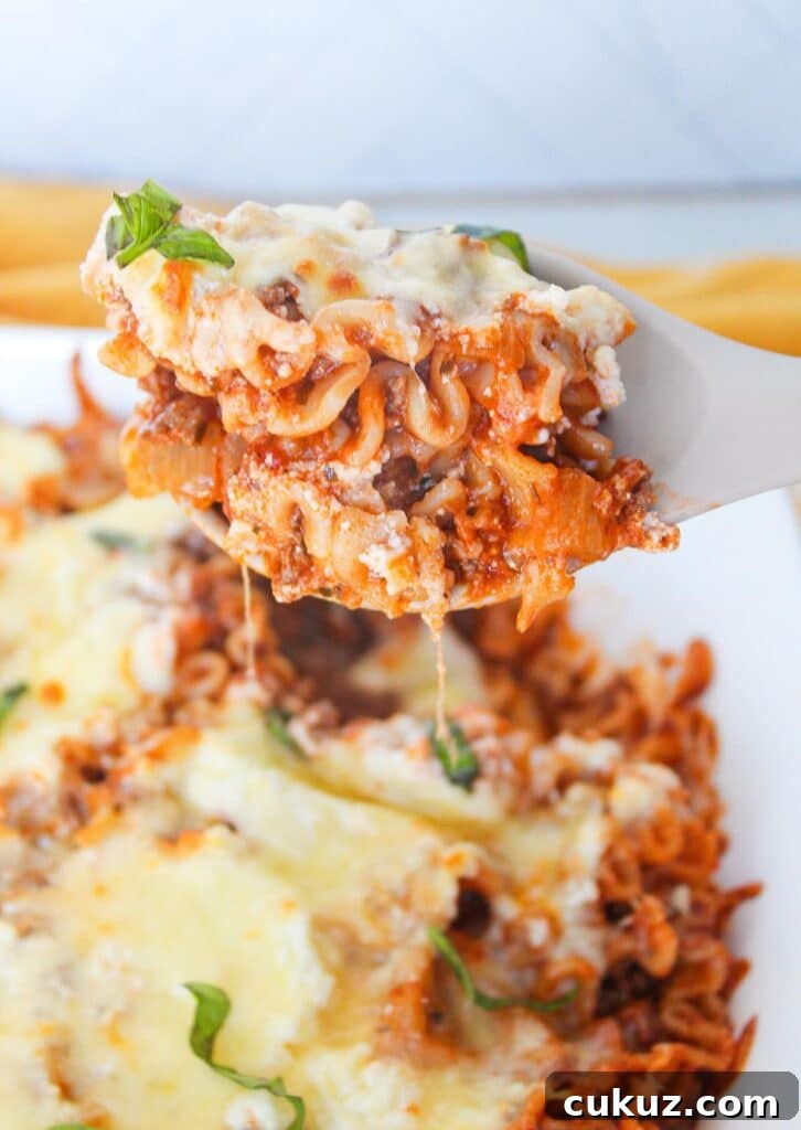 A close up shot of a scoop of deconstructed lasagna on a serving spoon.