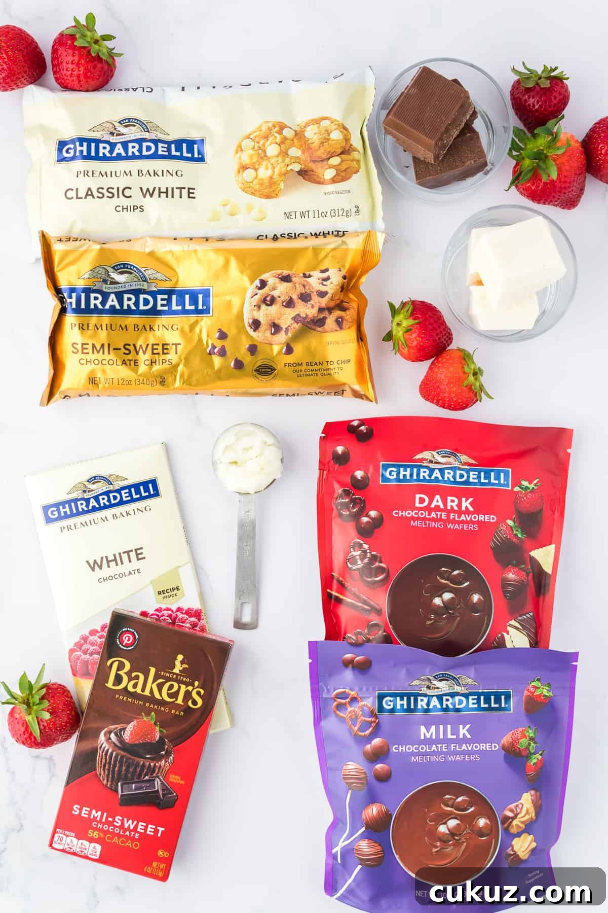 Ingredients for chocolate covered strawberries including fresh strawberries, a bag of ghiradelli classic white chips, ghiradelli semi sweet chocolate chips, white chocolate bar, semi-sweet chocolate, dark chocolate melting wafers and milk chocolate melting wafers, and coconut oil