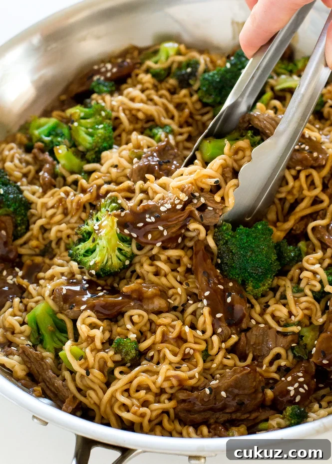 Beef and broccoli ramen recipe in a large skillet. Tossed in delicious sauce and steamed broccoli. Garnished with sesame seeds.