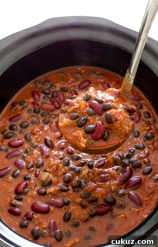 Slow cooked chili in a crock pot. Loaded with black and kidney beans.