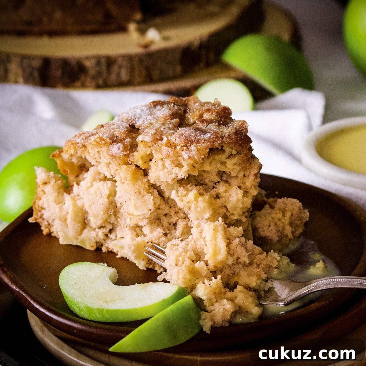 Someone using a fork to cut into a slice of Irish Apple Cake. 