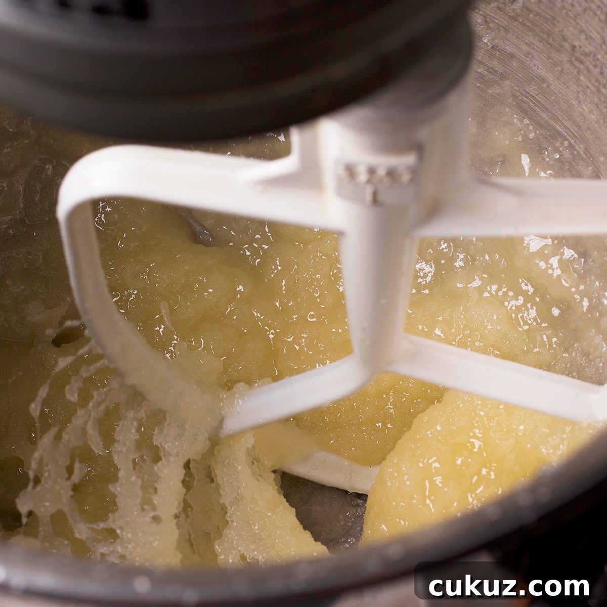 Using an electric mixer to beat butter and sugar.