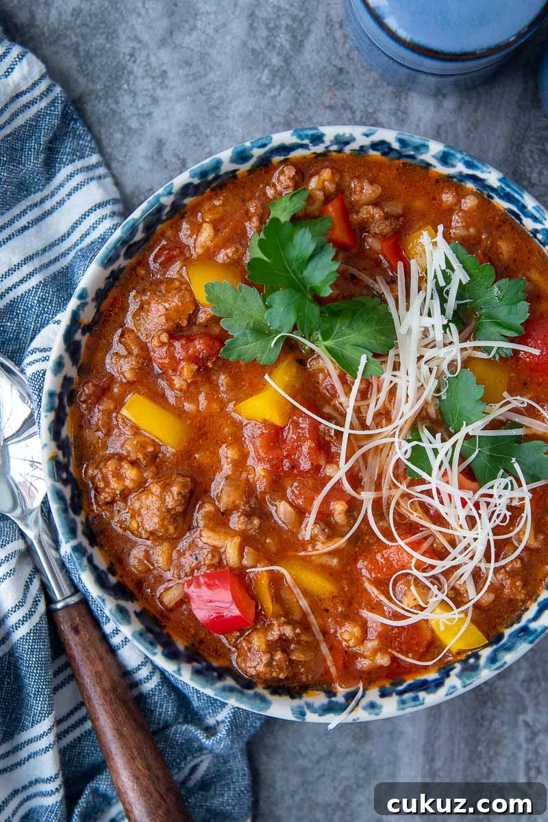 overhead shot of stuffed pepper soup in a blue bowl with blue napkin next to it