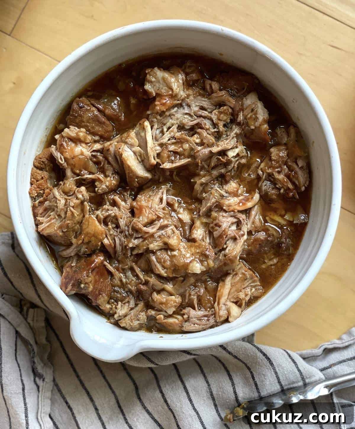 Instant Pot Country-Style Ribs with Tender, Fall-Off-the-Bone Results 2 A white bowl of instant pot country style boneless ribs coated in sauce and broth.