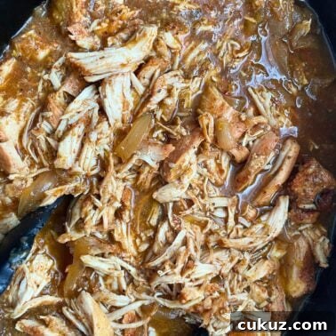 Instant Pot Country-Style Ribs with Tender, Fall-Off-the-Bone Results 9 A close-up view of chicken and onions cooked in salsa verde with taco seasoning in a slow cooker.